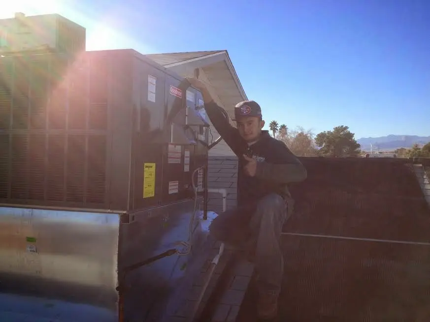 HVAC technician performing AC Tune-Up on a rooftop unit in Panama City